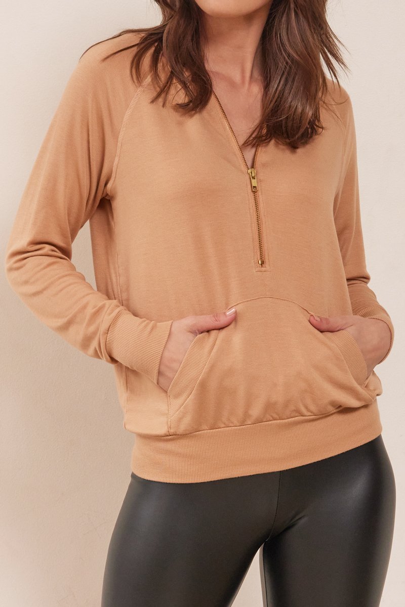 close up of half zip hoodie with front pocket in camel color
