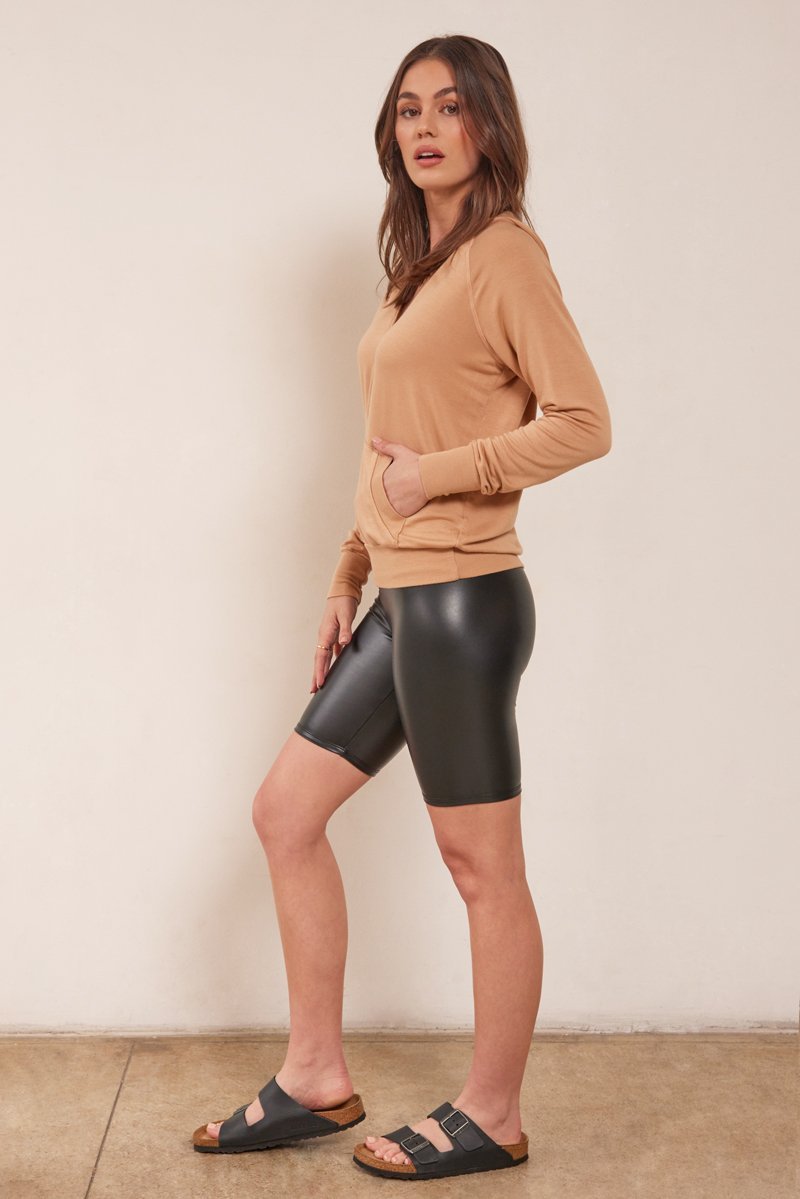full body image with camel colored half zip hoodie and vegan leather bike short