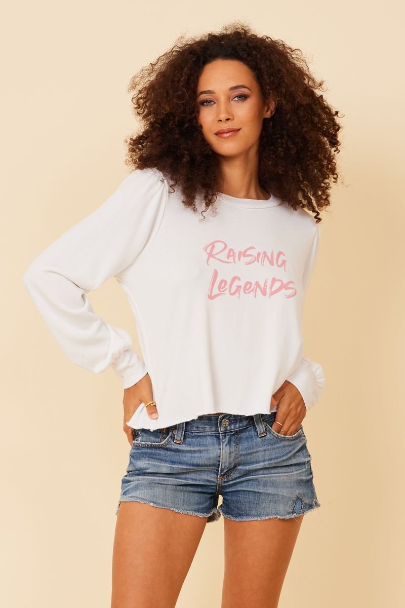 white feminine sweatshirt with pink raising legends text
