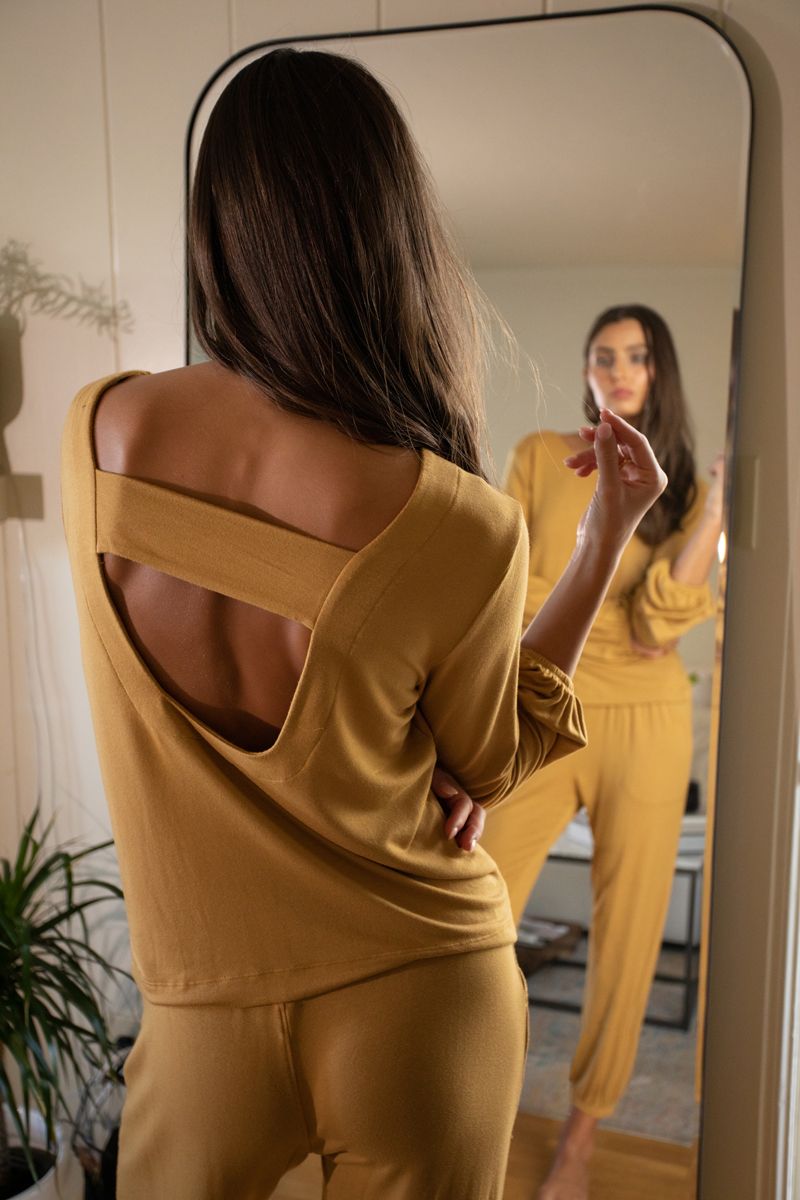 model looking in mirror in camel colored matching lounge set of pants and long sleeve